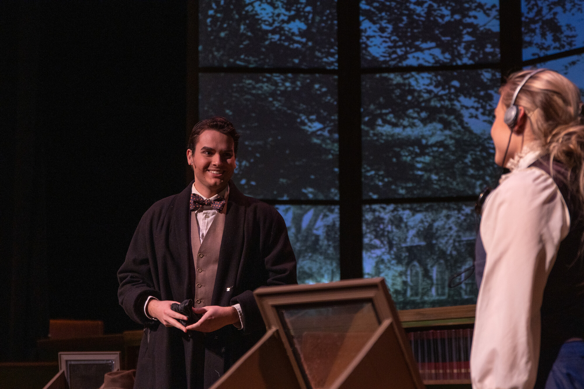 two actors on dark, moody stage